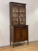 A Sheraton revival mahogany bookcase on cabinet, circa 1900, the dentil cornice over marquetry