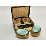 A Birmingham silver celadon green guilloche enamel three piece child's hair brush set comprising a