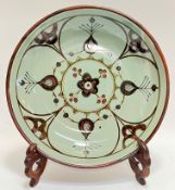 A large Highland Stoneware charger/dish decorated in tenmoku/iron slip with celadon glaze (marked