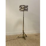 An early 20th century brass telescopic standard light, the octagonal post raised on three scrolled