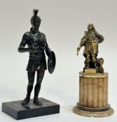 A gilt-metal desk bronze of a figure in 17th century dress, a helmet at his feet, mounted on a