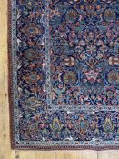 A fine hand knotted central Persian rug, the dark blue field and border decorated with repeating