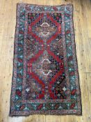An antique Turkish hand knotted rug, the deep red field decorated with geometric pole medallion,
