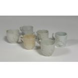 A group of 18th century Bow porcelain white-glazed cups, c. 1750-60, each moulded with prunus,