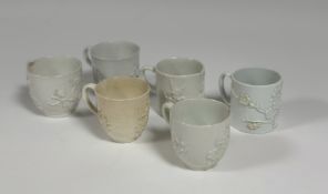 A group of 18th century Bow porcelain white-glazed cups, c. 1750-60, each moulded with prunus,