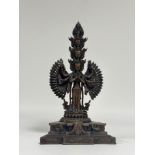 An Indo-Chinese patinated bronze Avalokitesvara, eleven-headed, modelled standing on a triangular