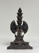 An Indo-Chinese patinated bronze Avalokitesvara, eleven-headed, modelled standing on a triangular