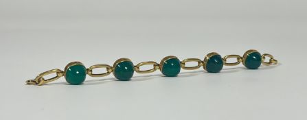 A 20th century yellow metal bracelet, set with five cabochon green semi-precious stones, possibly