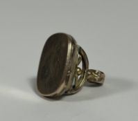 A yellow metal seal locket, c. 1900, the loop handle on scrolling supports over a rectangular