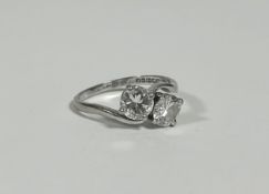 A two-stone diamond ring, the pair of round brilliant-cut stones claw-set in a crossover setting