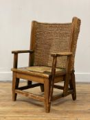 A Scottish pine child's Orkney chair, circa 1920's, the woven rush back and cord seat flanked by