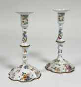 A pair of Staffordshire painted enamel candlesticks, last quarter of the 18th century, in two