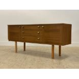 A mid century teak veneered sideboard, with three centre drawers flanked by two cupboards, each