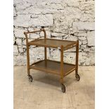 A mid century teak and laminate two tier drinks trolley moving on castors. H75cm, 69cm x 46cm