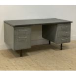 A mid century pressed steel machinists desk, the rectangular top above five drawers, raised on