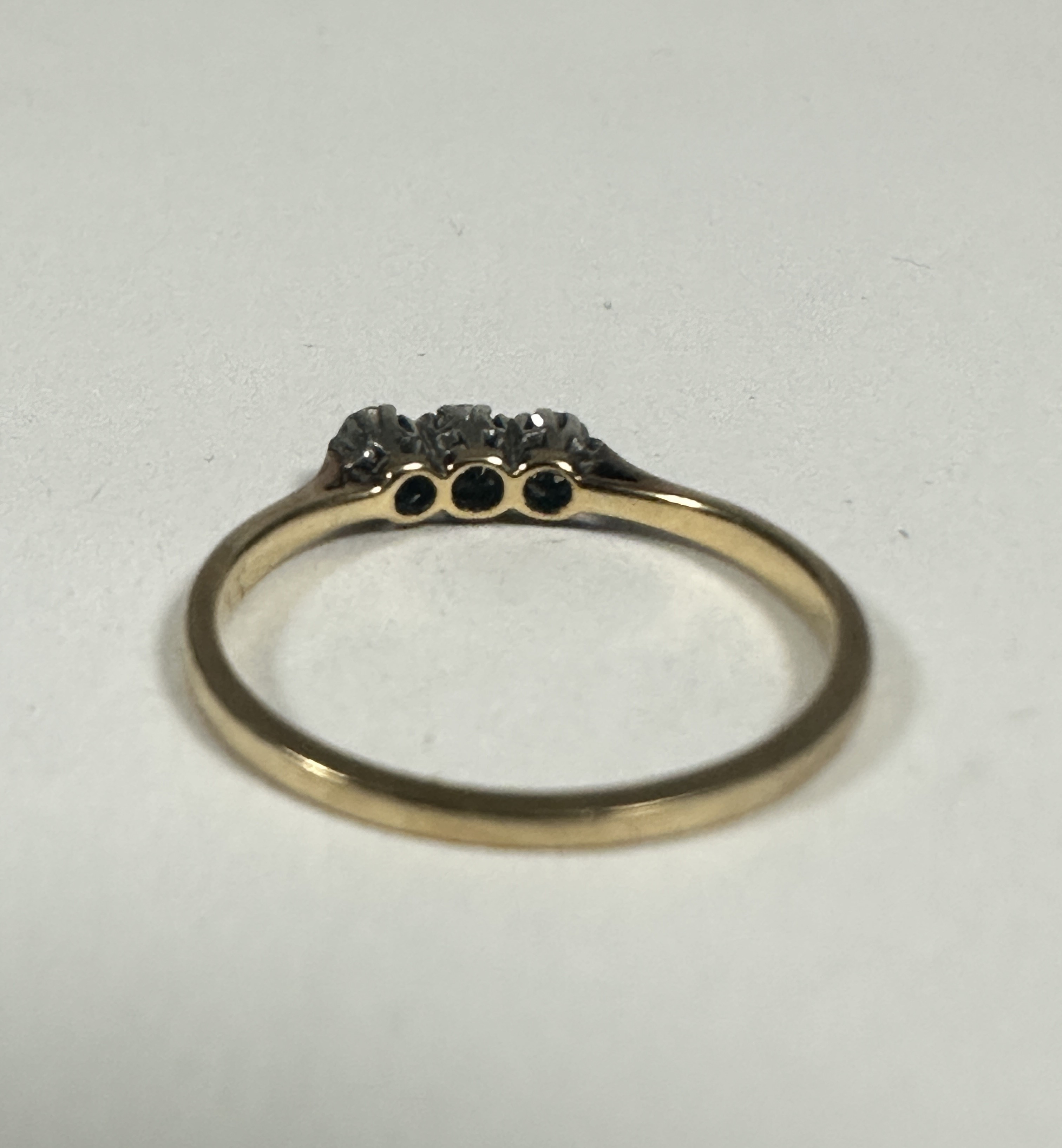 A 9ct gold three stone diamond ring set in platinum claw setting, K. 1.06g - Image 3 of 3