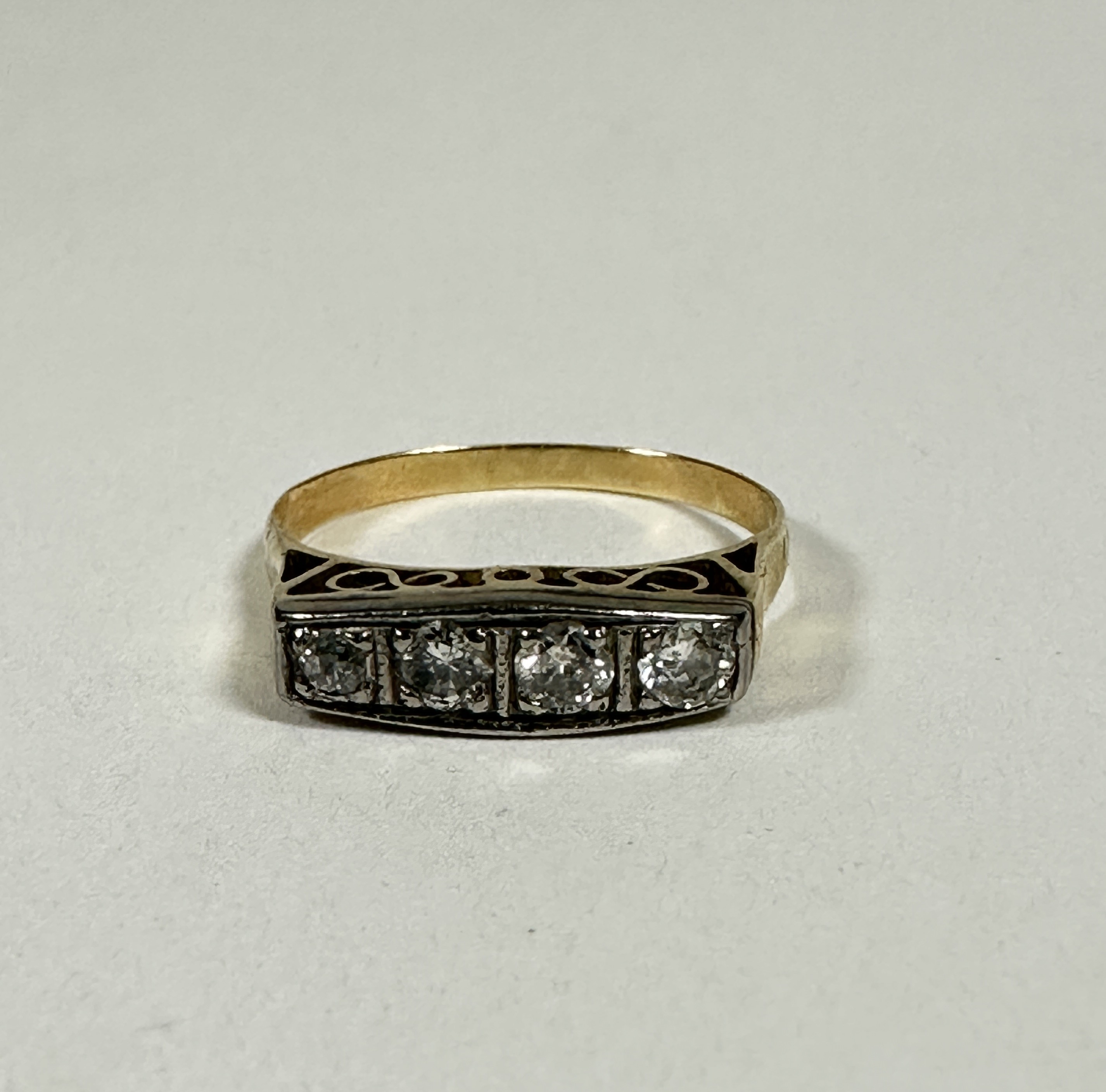 An Edwardian yellow and white metal ring set four graduated old cut Diamonds in millegrain