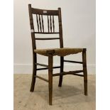 An early 20th century stained beech framed country side chair with rush seat raised on turned