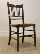 An early 20th century stained beech framed country side chair with rush seat raised on turned