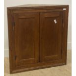 A 19th century pine wall hanging corner cupboard, two panelled doors enclosing two shelves H92cm,