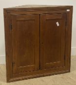 A 19th century pine wall hanging corner cupboard, two panelled doors enclosing two shelves H92cm,