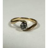 A 18ct gold solitaire Diamond ring in rubover setting on cross over band, 0.20ct approximately, H.