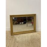 A gilt composition framed wall hanging mirror gadrooned, cavetto moulded frame enclosing a