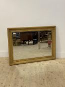 A gilt composition framed wall hanging mirror gadrooned, cavetto moulded frame enclosing a