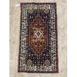 A Persian hand knotted rug, the dark field with geometric and stylised foliate design, within an
