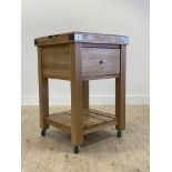 A contemporary oak butchers block style kitchen work table, with lift of tray top over a drawer,