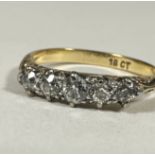 A 18ct gold graduated five stone Diamond ring, the old cut stones mounted in white metal claw