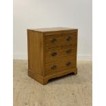 An Edwardian satin walnut three drawer chest with tramline moulding, raised on bracket supports