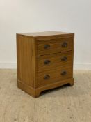 An Edwardian satin walnut three drawer chest with tramline moulding, raised on bracket supports