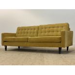 A large contemporary sofa, upholstered in yellow chenille type fabric, raised on ebonised square