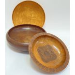 Three treen bowls including a shallow maple bowl, a larger oak bowl (w- 28cm), and a carved teak