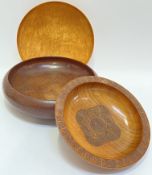 Three treen bowls including a shallow maple bowl, a larger oak bowl (w- 28cm), and a carved teak