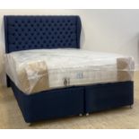 A contemporary 5'3" queen bed, with a deep buttoned upholstered headboard, divan base moving on