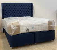 A contemporary 5'3" queen bed, with a deep buttoned upholstered headboard, divan base moving on