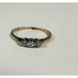 A 9ct gold three stone diamond ring set in platinum claw setting, K. 1.06g