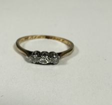 A 9ct gold three stone diamond ring set in platinum claw setting, K. 1.06g