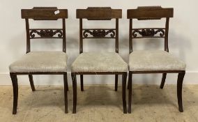 A set of three Regency inlaid mahogany chairs, with upholstered seats and raised on sabre supports