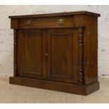 An Edwardian walnut side cabinet, fitted with a drawer above two panelled cupboards enclosing a