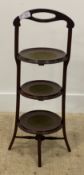 An Edwardian mahogany three tier cake stand, each tier inset with baize raised on four splayed