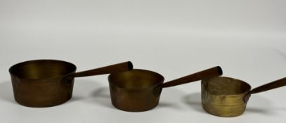 A set of three graduated brass sauce pans with iron handles, D x 17.5cm , 15cm , 13cm,) (3)