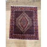 A hand knotted Persian Hamadan rug, the central field with lozenge medallion and bordered 158cm x