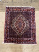 A hand knotted Persian Hamadan rug, the central field with lozenge medallion and bordered 158cm x