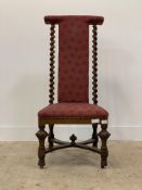 A Victorian walnut prie dieu of Carolean design, the upholstered crest and back enclosed by spiral