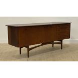 A mid century teak sideboard, the shaped top above a large fall front cocktail cabinet, flanked by