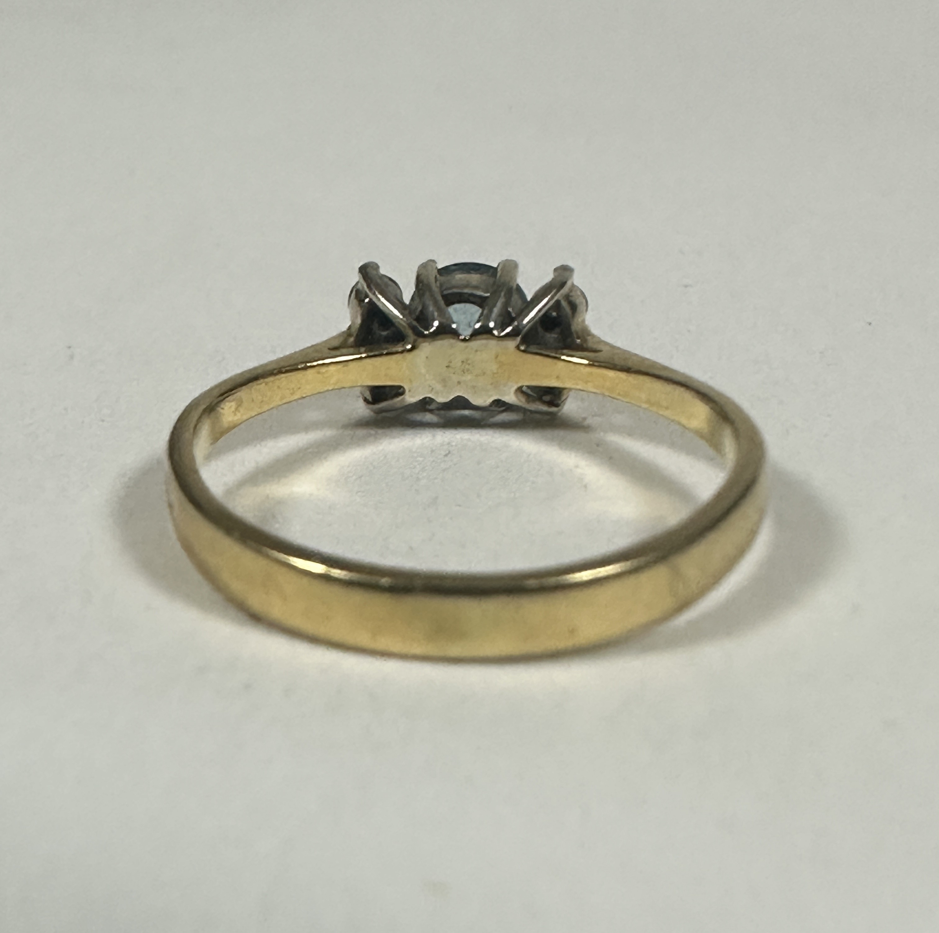 A 18ct gold Aquamarine ring, the circular stone approximately 0.33ct flanled by tow clear stones, K. - Image 3 of 3