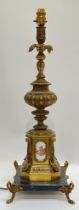 A large Rococo style gilt metal and porcelain lamp on marble base, the porcelain plaques decorated